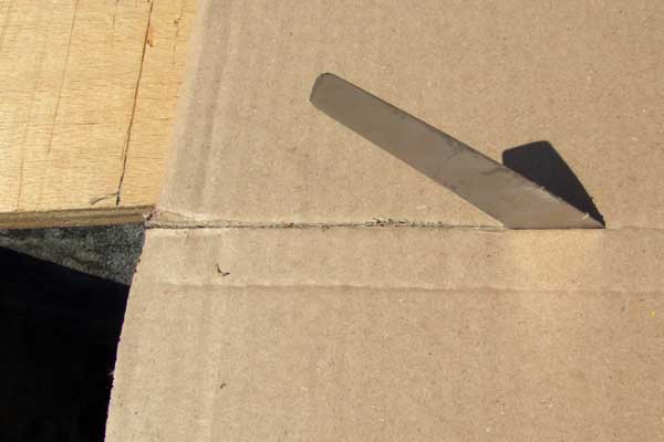 A cobbler's knife cutting a cardboard box