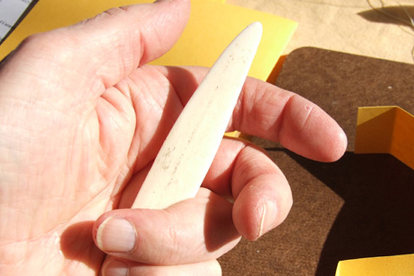 Holding a bone folder whilst working with bookcrafts 