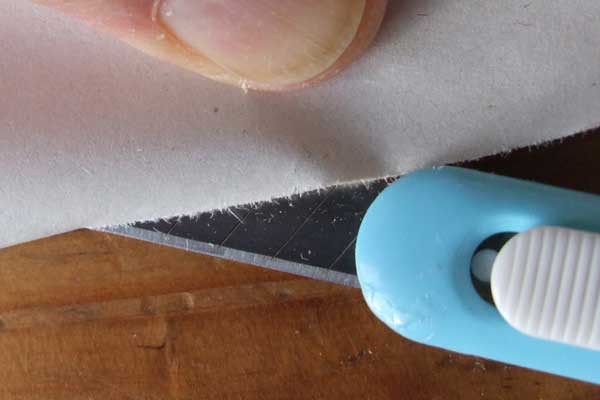 Cutting a folded sheet of paper with a sharp knife