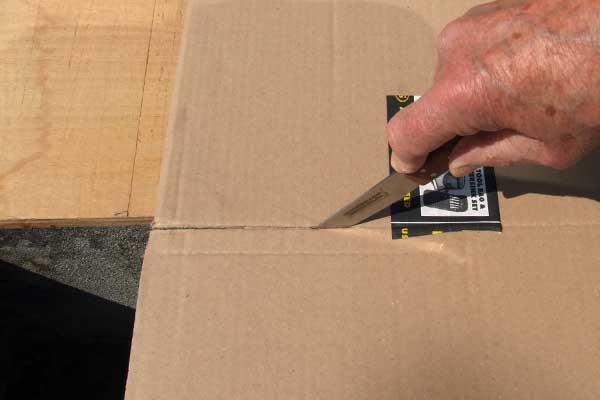 A cobbler's knife cutting a cardboard box